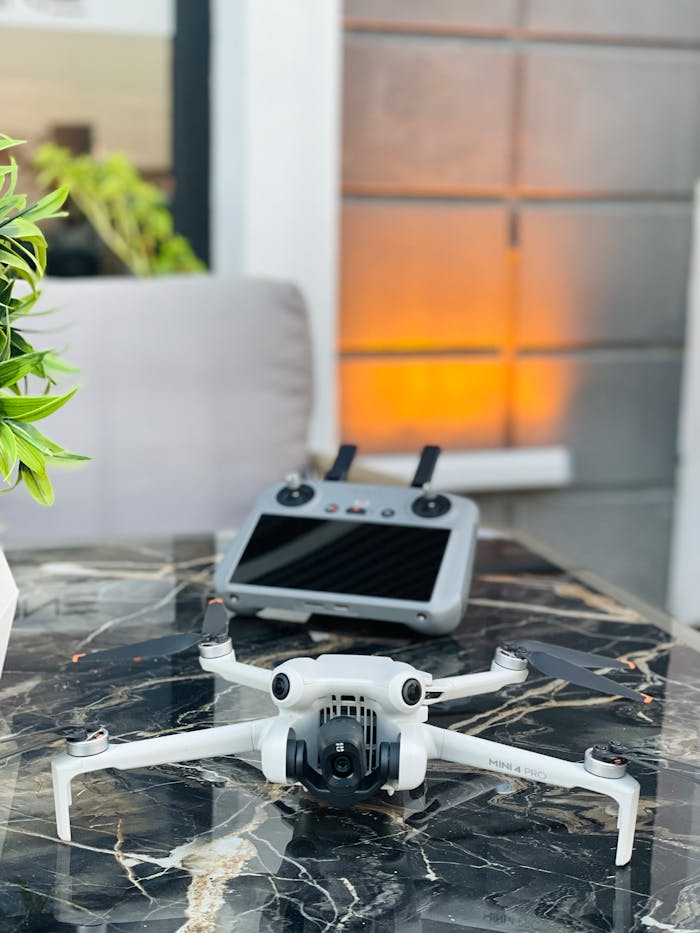 A modern drone with its controller on a stylish marble table indoors, capturing a sleek tech vibe.